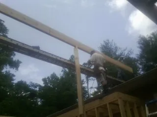 Carpenter setting a ridge beam over a new addition frame — Ice Dam Removal by Roofing Brothers in Waterville Valley